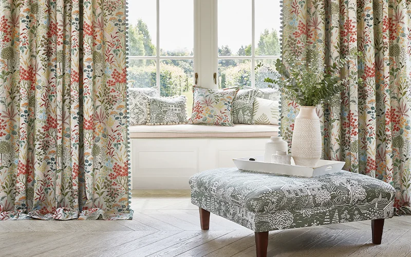 This image shows made to measure curtain fabrics with matching cushions and a large footstool. Create a cohesive interior style at Holcombe Interiors Showroom at Pendle Village mill, Near Burnley Lancashire